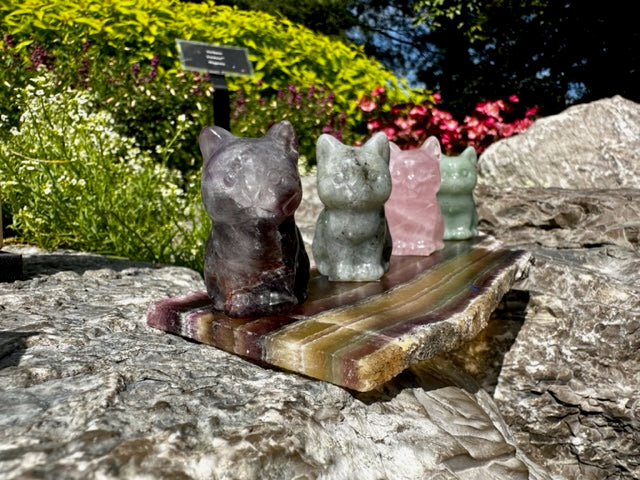 A set of 3 crystal cat miniatures ontop of a crystal slate